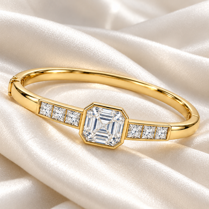 MISSISSI U10 Asscher-cut lab-grown diamond closed oval bangle in 14K yellow gold, ivory silk still life, with three princess-cut diamonds on each shoulder.