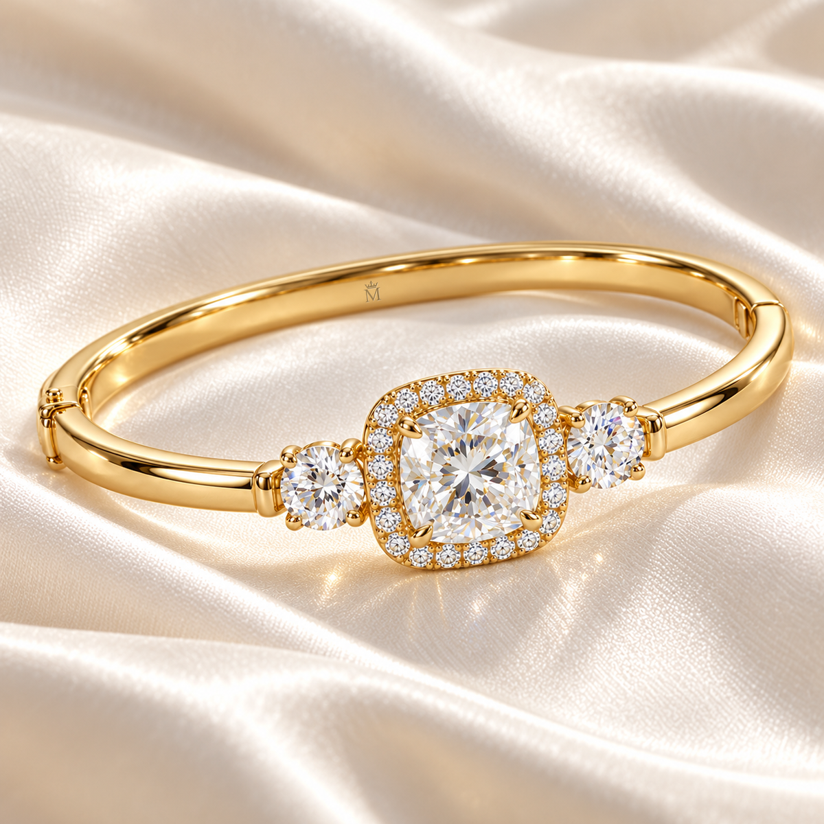MISSISSI U11 cushion-cut lab-grown diamond halo closed oval bangle in 14K yellow gold, ivory silk still life, with one round diamond on each shoulder.