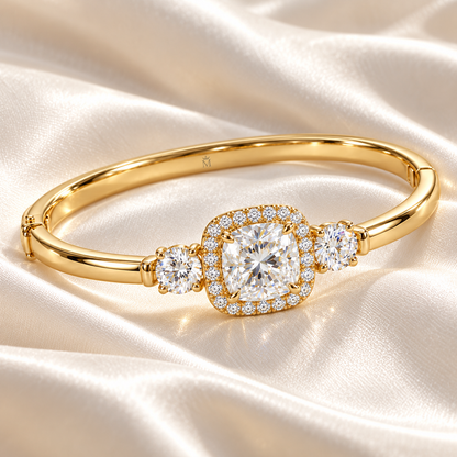 MISSISSI U11 cushion-cut lab-grown diamond halo closed oval bangle in 14K yellow gold, ivory silk still life, with one round diamond on each shoulder.