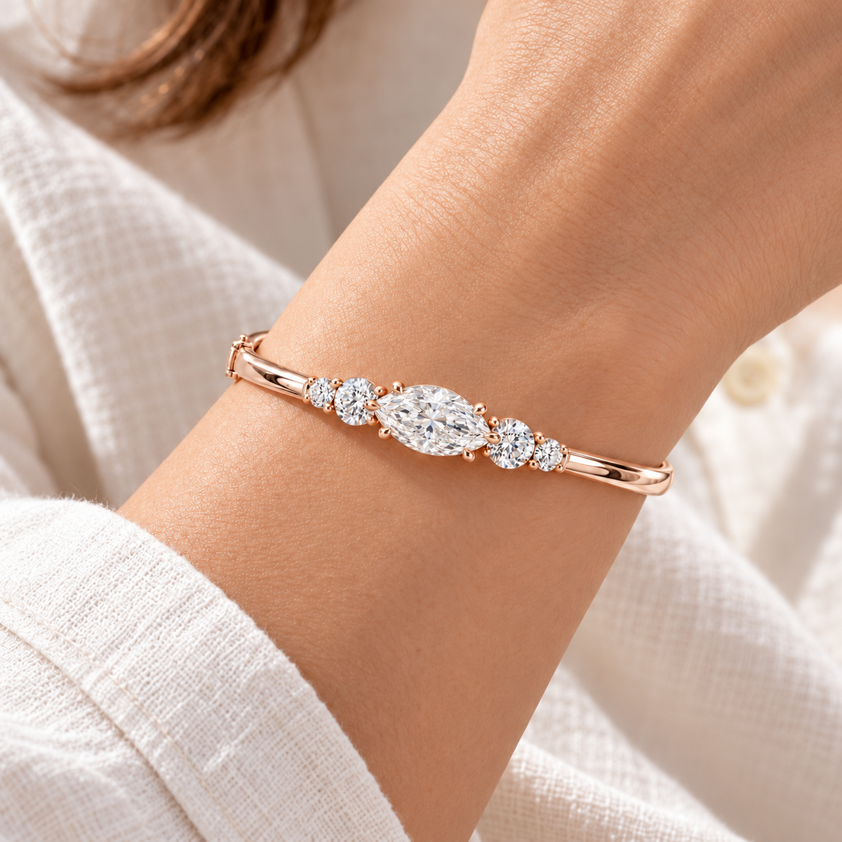MISSISSI U12 east-west marquise-cut lab-grown diamond closed oval bangle in 14K soft rose gold, adult wrist worn view, with two graduated round diamonds on each shoulder.