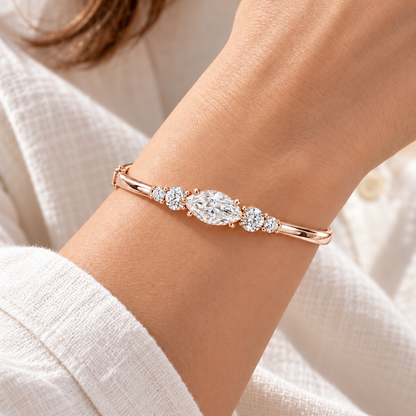 MISSISSI U12 east-west marquise-cut lab-grown diamond closed oval bangle in 14K soft rose gold, adult wrist worn view, with two graduated round diamonds on each shoulder.